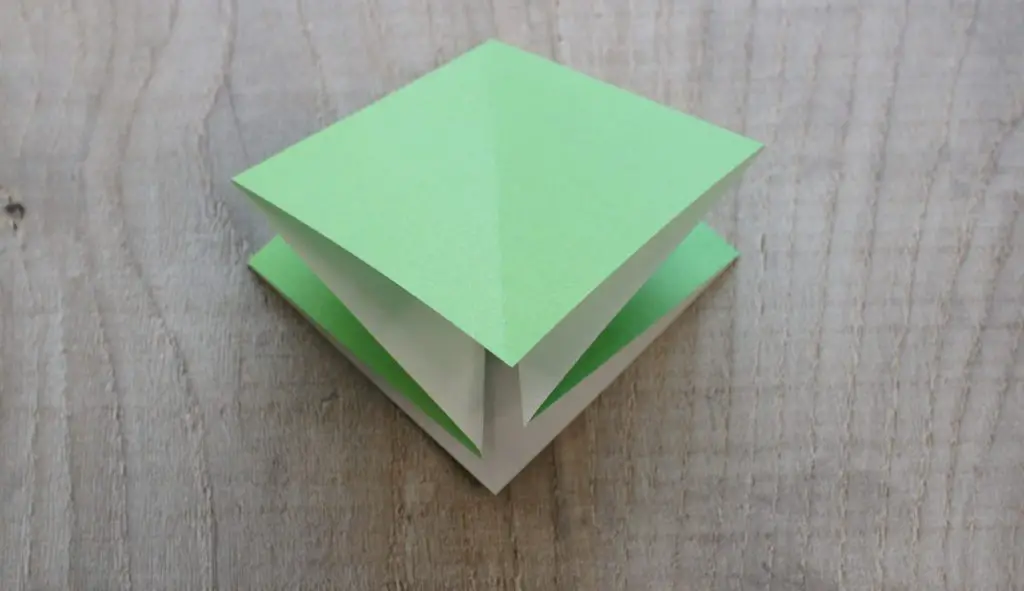 paper folded into small square showing folds