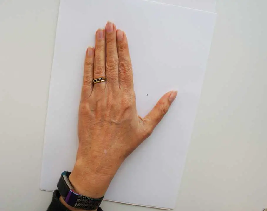 hand on paper to make mitten pattern