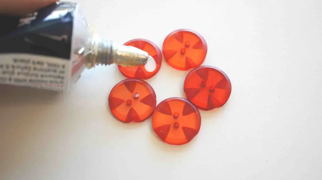 glue being put on red buttons