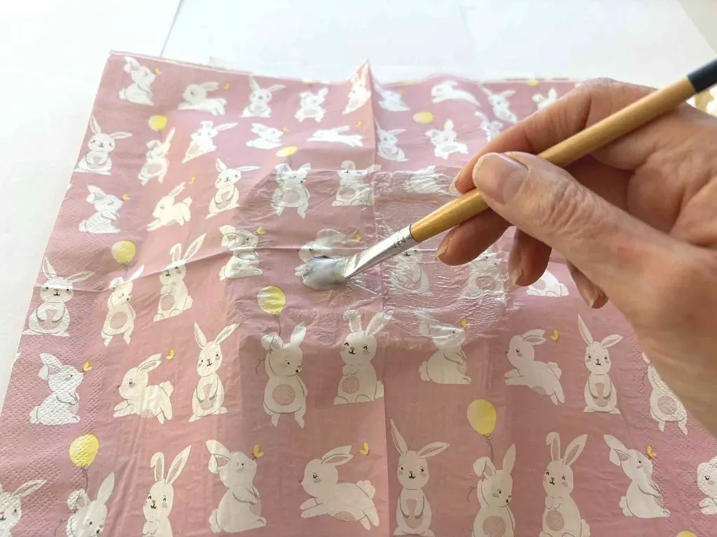 applying glue over the napkin on the plastic container