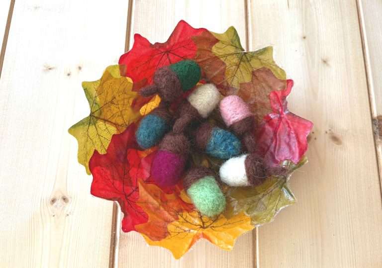 needle felted acorns in an autumn leaf basket