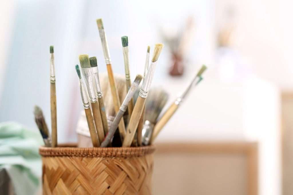 paintbrushes in a pot with blurred background