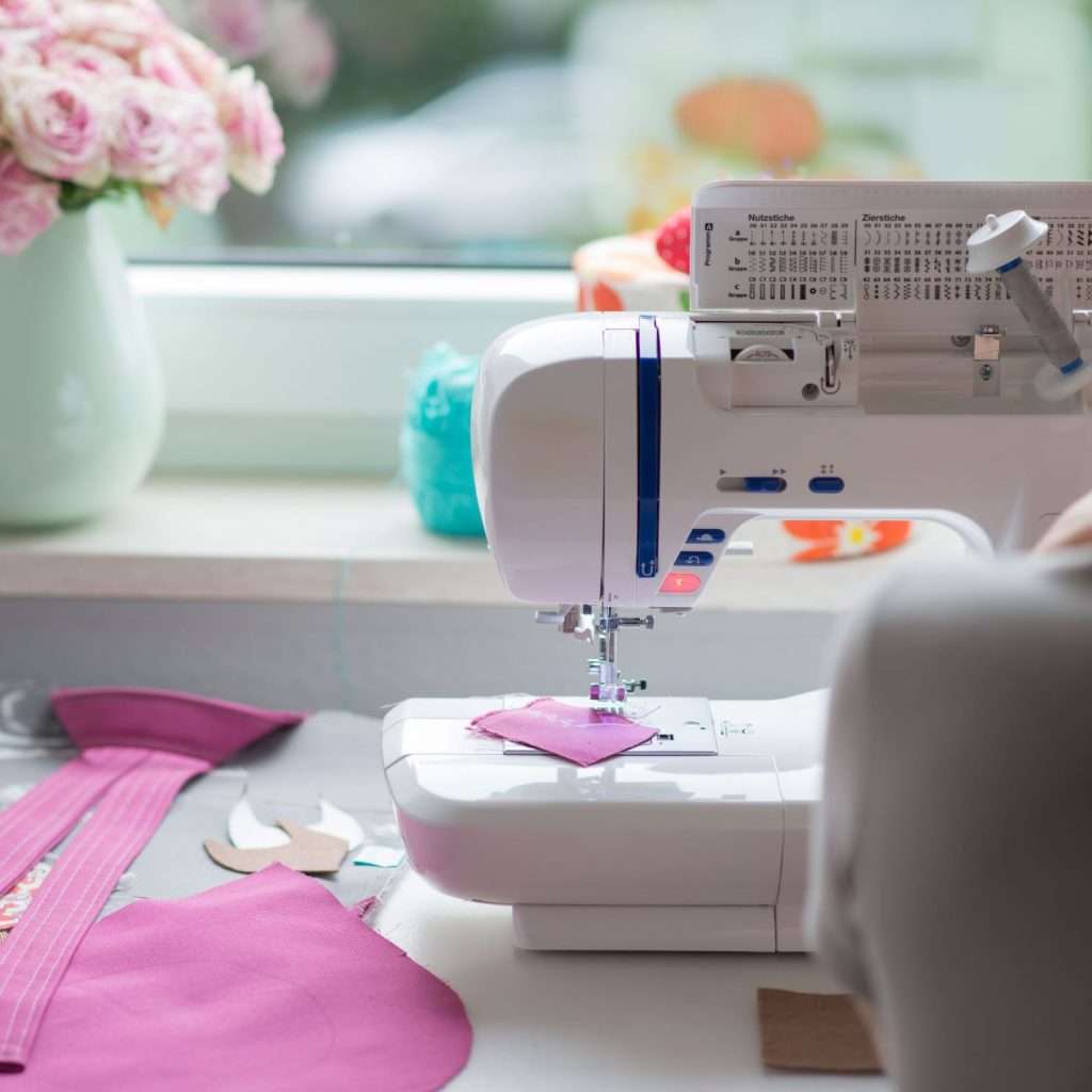 sewing machine sewing pink fabric