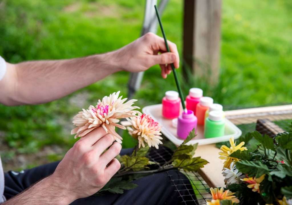 someone painting a flower outdoors