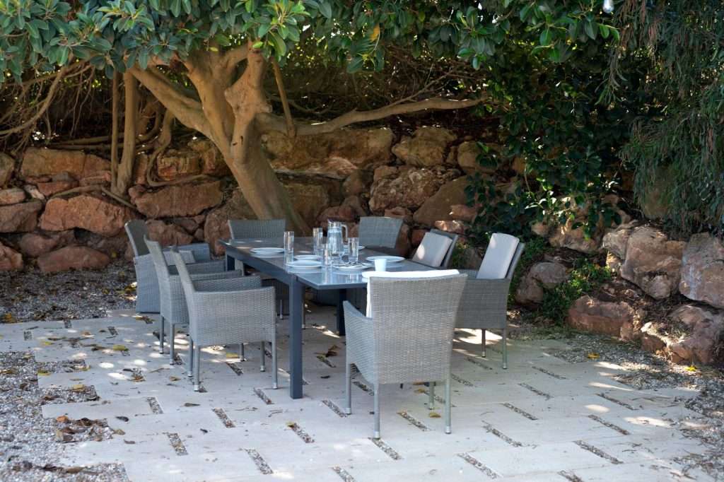 outdoor dining table and chairs under a tree